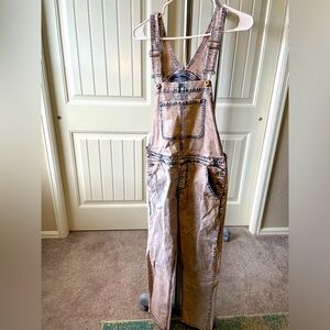 Light pink bleached denim overalls.